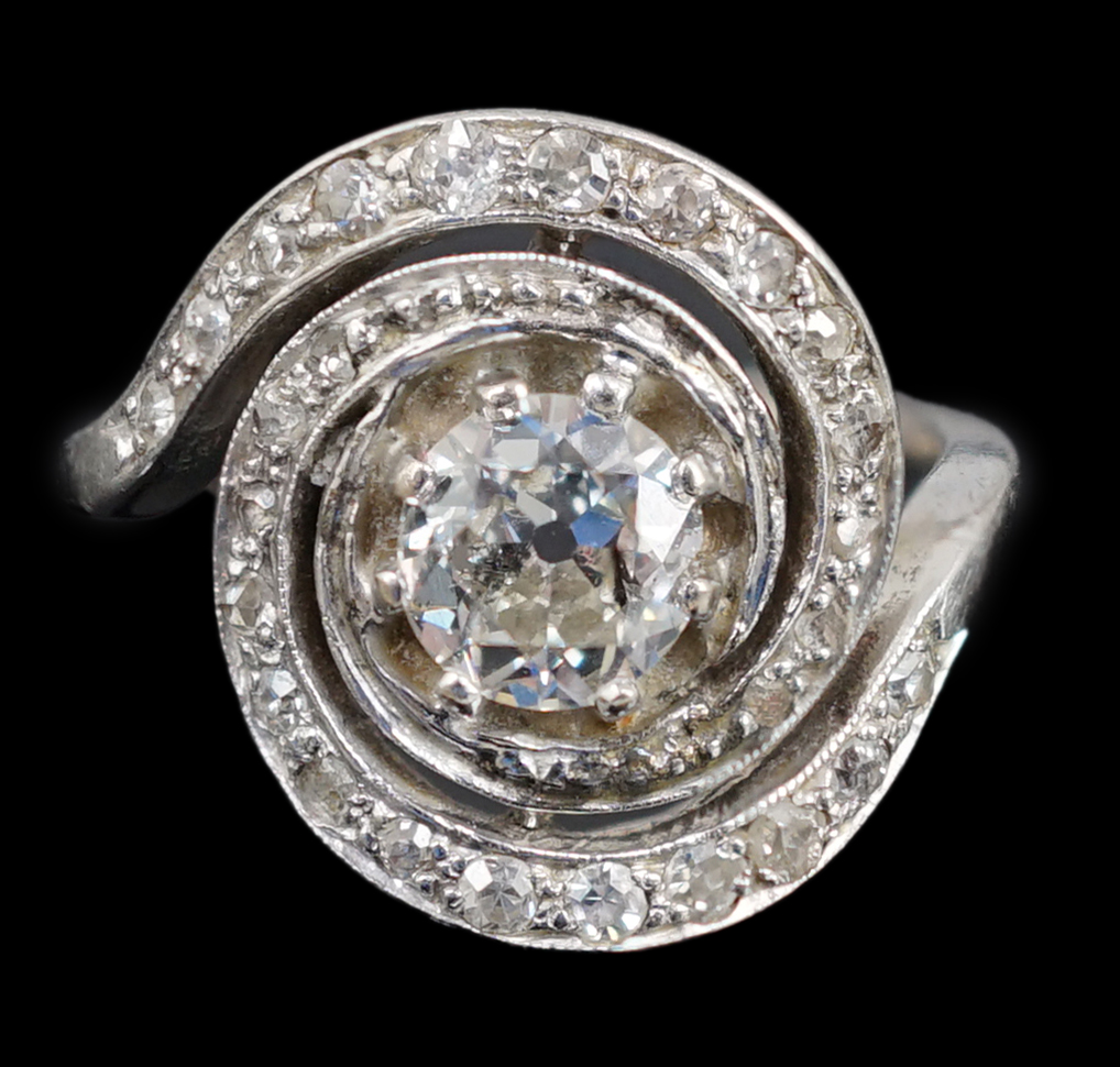 A mid 20th century platinum and diamond cluster set ring, of spiralling design